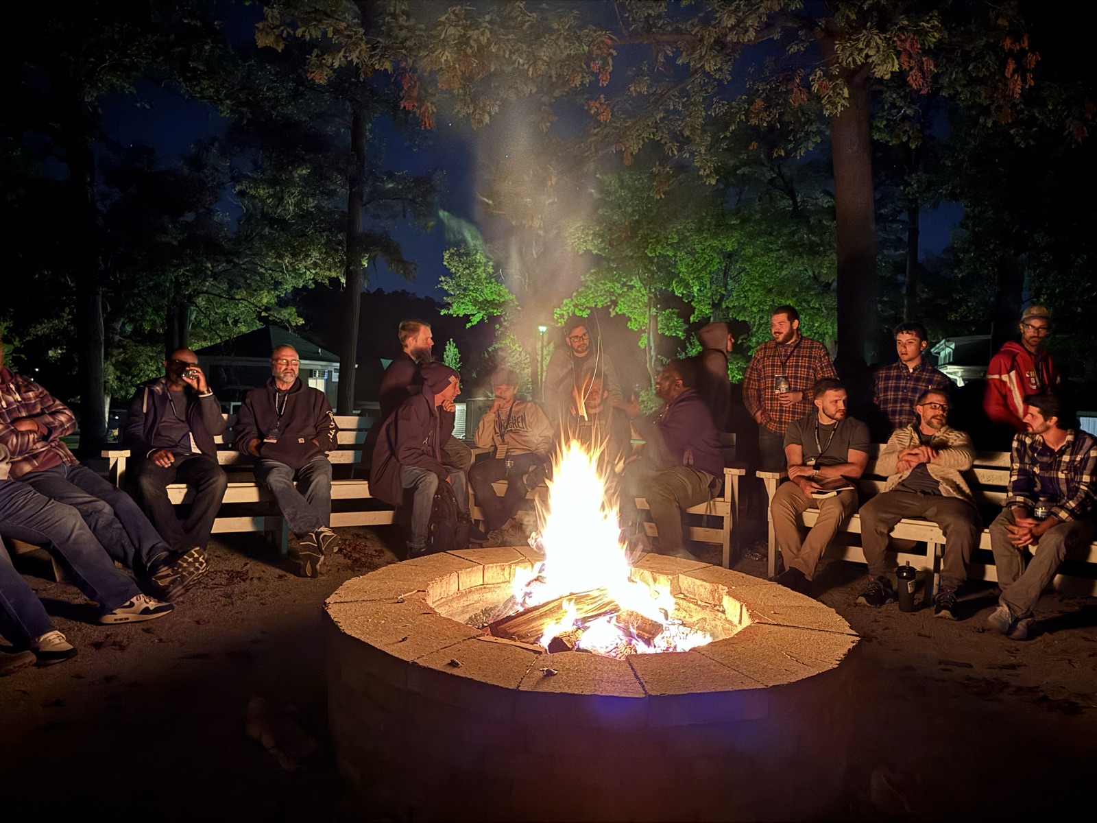 Men gathered around the fire at night
